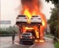 Driver reverses new car off of blazing transporter
